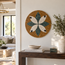 Round handmade mosaic floral wall art with teal and white flower on tan tile background