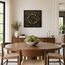 Framed stone mosaic wall art with gold swirl above a sideboard in a dining room