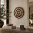 Round handmade stone mosaic wall art with concentric earth-tone circles, centered
