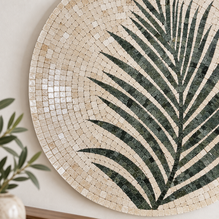 Large round stone mosaic wall art showing dark green palm leaf lines on cream tiles