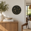 Round handmade stone mosaic wall art with black stone pieces and gold highlights