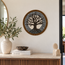 Round stone mosaic wall art with tree design in gray, black, and gold border.