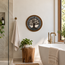 Round stone mosaic wall art featuring a black tree silhouette with gold-toned rim.