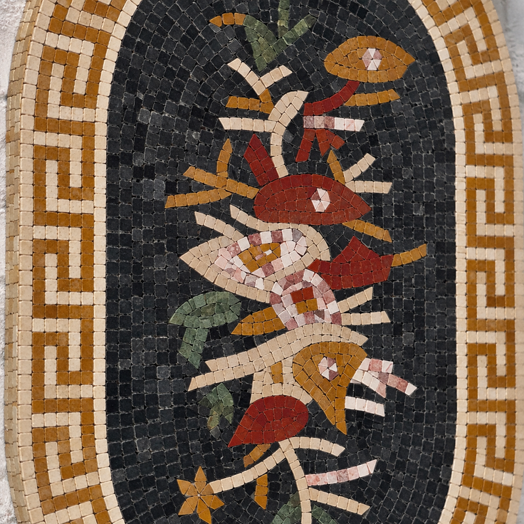 Close-up oval floral mosaic with Greek key border and multicolor flower pattern.