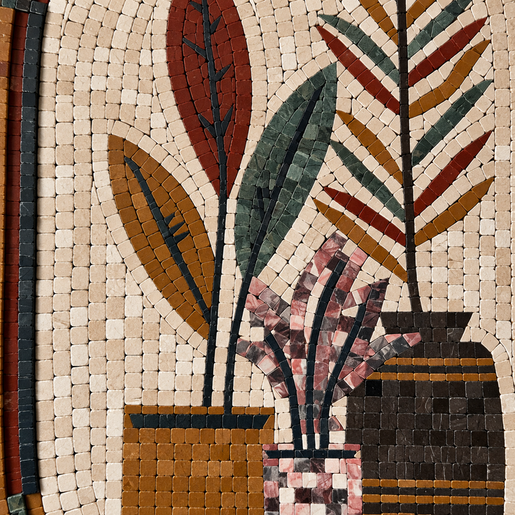 Close-up stone mosaic artwork with red and green leaf shapes and pot motifs