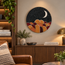 Round black mosaic wall art disc with crescent moon and orange arch mountains