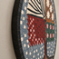 Close-up of round mosaic wall art tilework with red canopy, teal leaves, and pink circles.