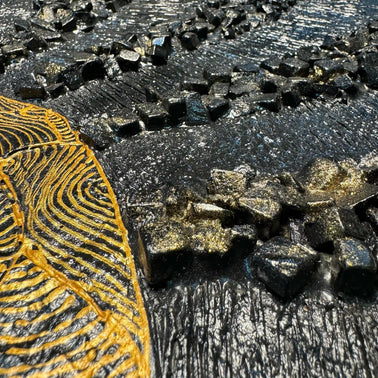 Two-panel mosaic wall art, close-up of gold and dark gray tile rays in an eclipse pattern